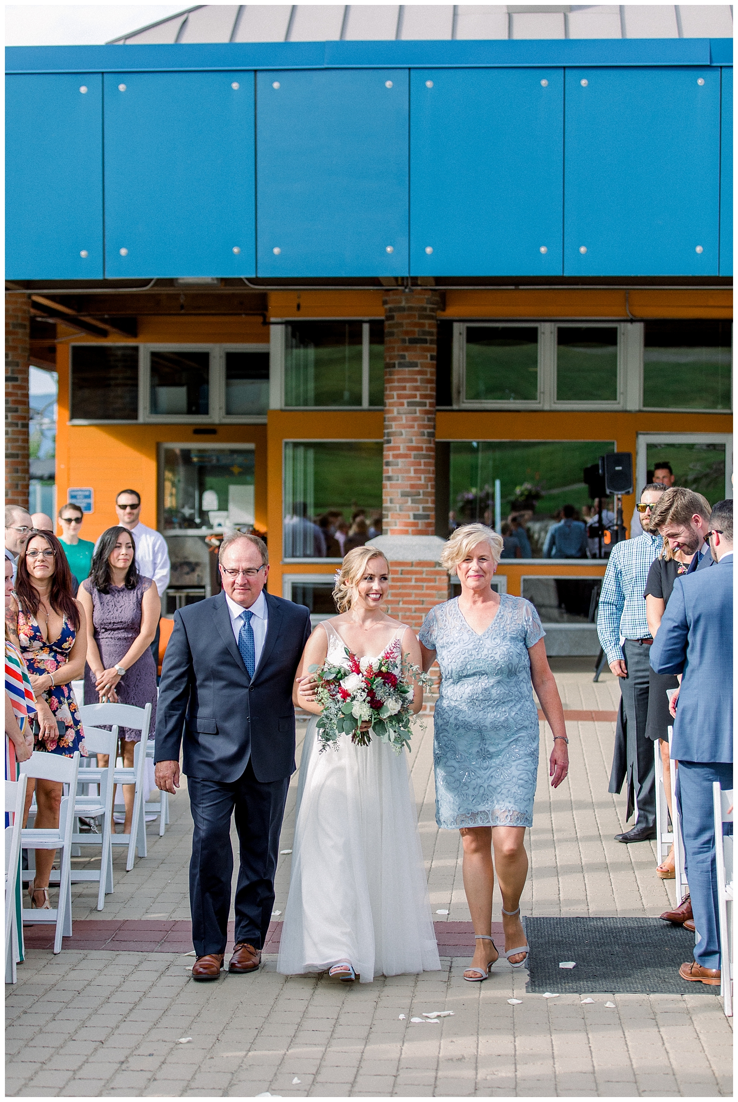 Father and mother walking daughter down the aisle at outside wedding ceremony at Sugarloaf Mountain Resort in Maine, photos by Halie Olszowy.