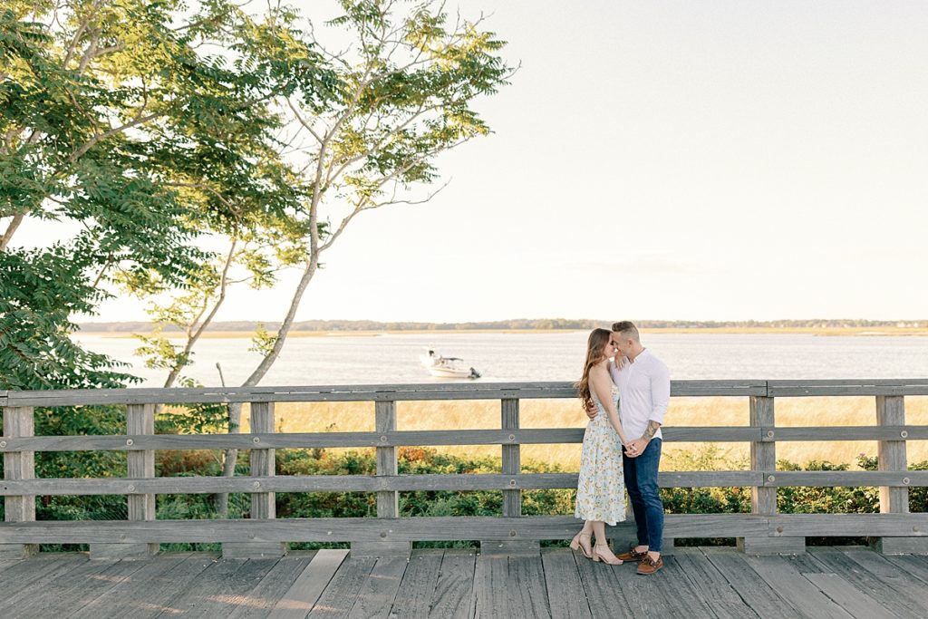 A couple embracing on Powder Point Bridge in Duxbury, MA