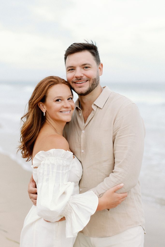 Couple on the beach smiling at the camera