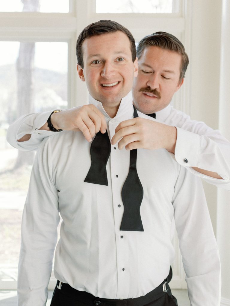Groom putting on a bow tie for Woodstock Inn wedding