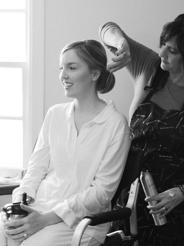 Bride getting her hair done on wedding morning for Vermont spring wedding