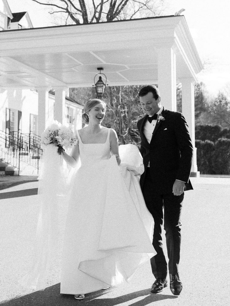 Bride and groom candid black and white portrait in front of the Woodstock Inn in Vermont