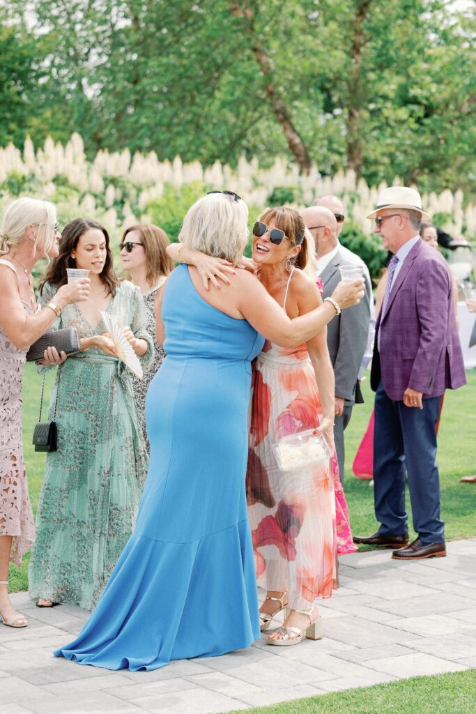Wedding guests greeting each other for outdoor wedding ceremony at Wentworth by the Sea