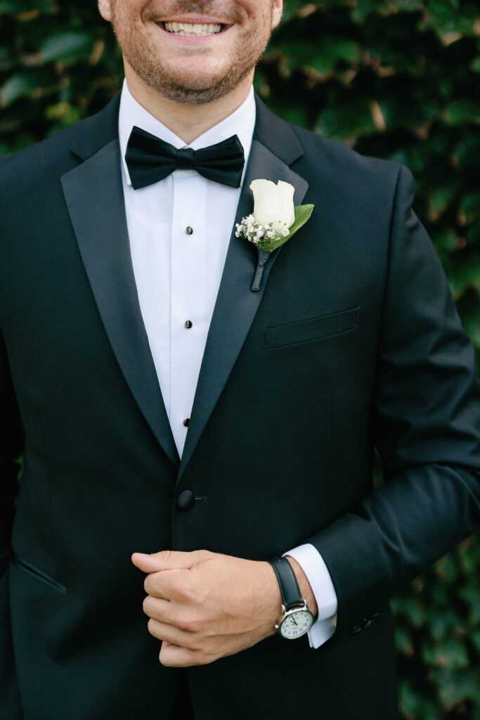 Groom detail shot wearing a tux with boutonniere and watch for Newport wedding