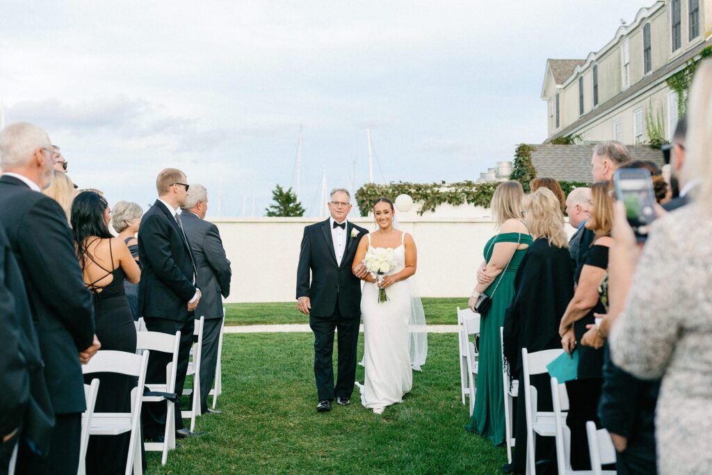 Bride walking down the aisle with her dad during Belle Mer wedding ceremony