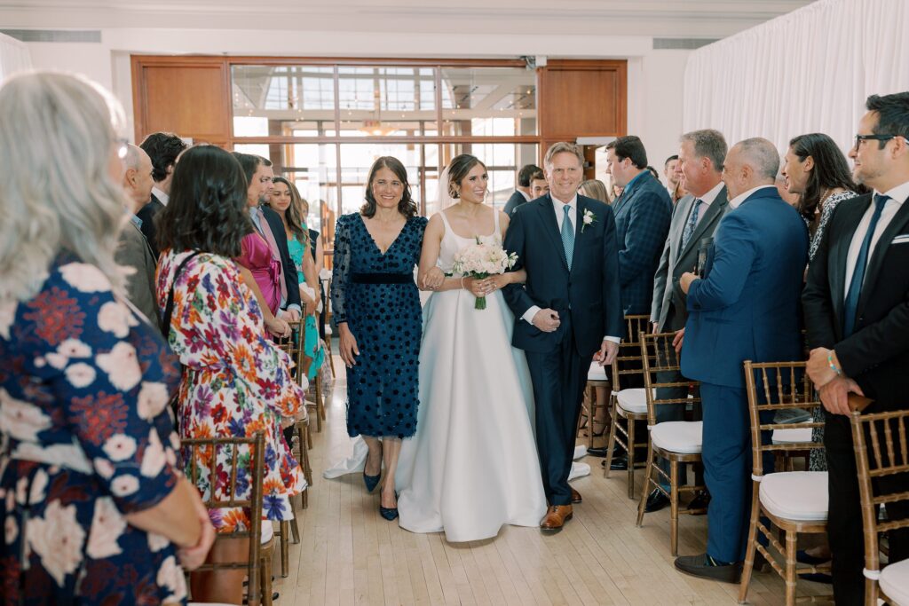 Bride walking down the aisle with her parents