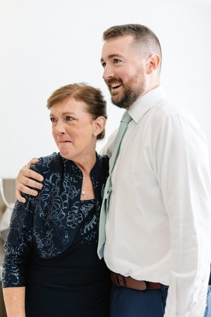 Groom and his mom getting ready before wedding