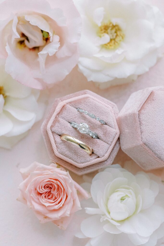 Detail photography of wedding bands and engagement ring in pink velvet box