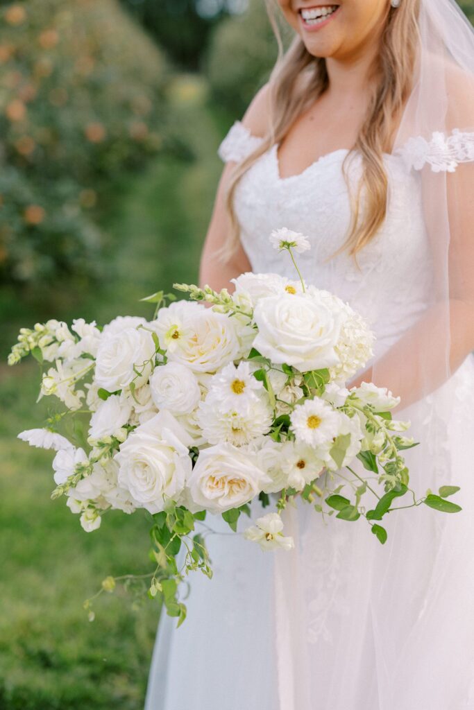 Bridal portrait with all-white bouquet in the orchard at The Greenery at McKenzie's Farm Wedding