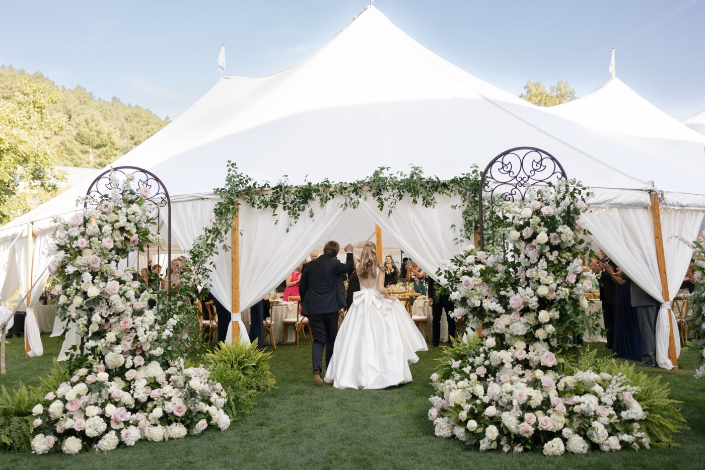 Bride and groom entering their tented wedding reception