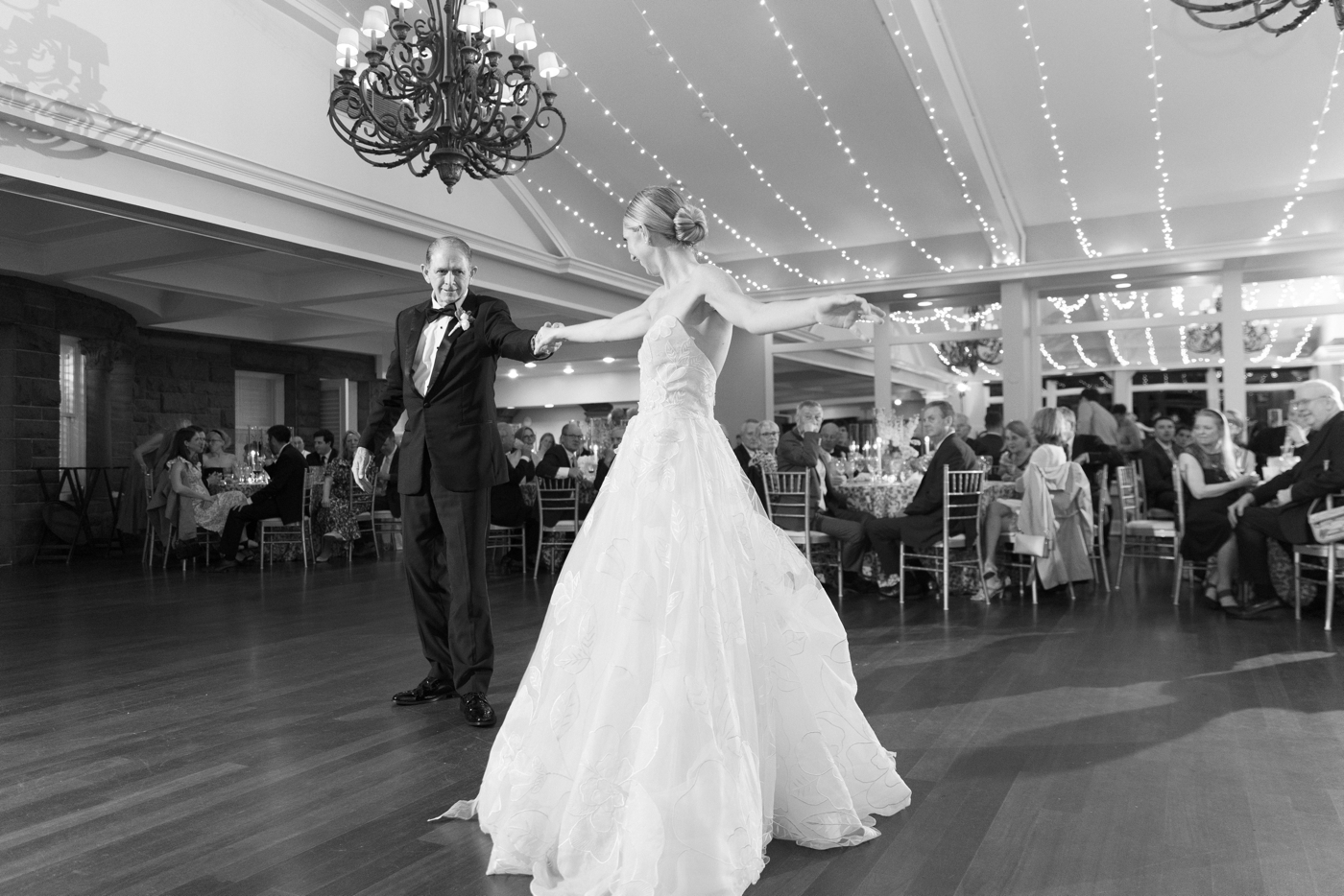 Black and white photo of bride and father dancing