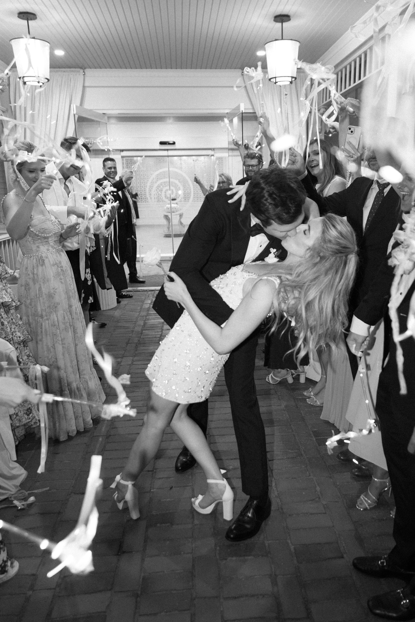 Groom kissing bride during wedding reception exit