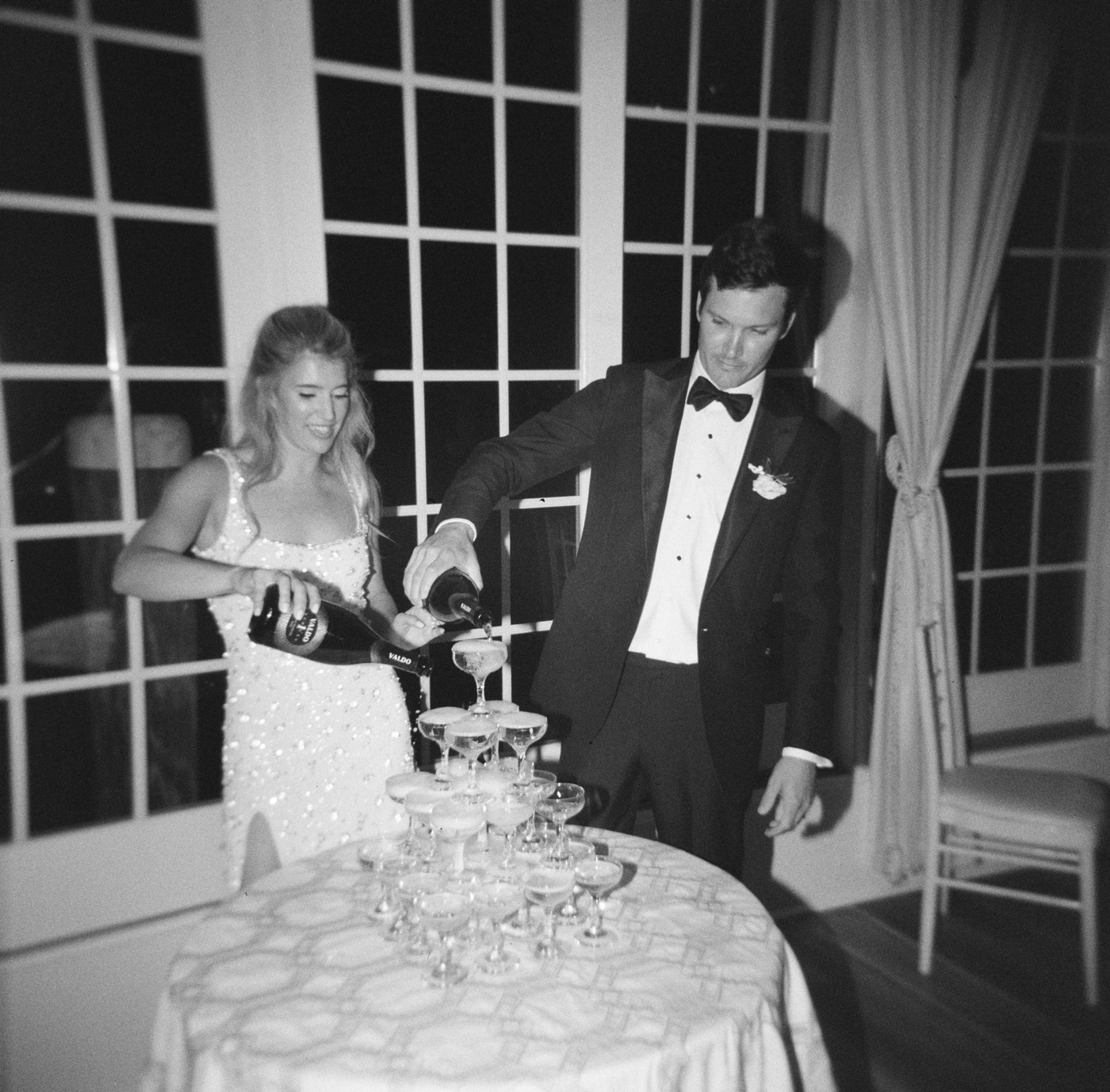Bride and groom pouring a champagne tower at their wedding reception